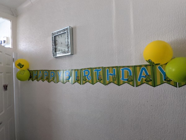Banner with balloons and frogs saying Happy Birthday!
