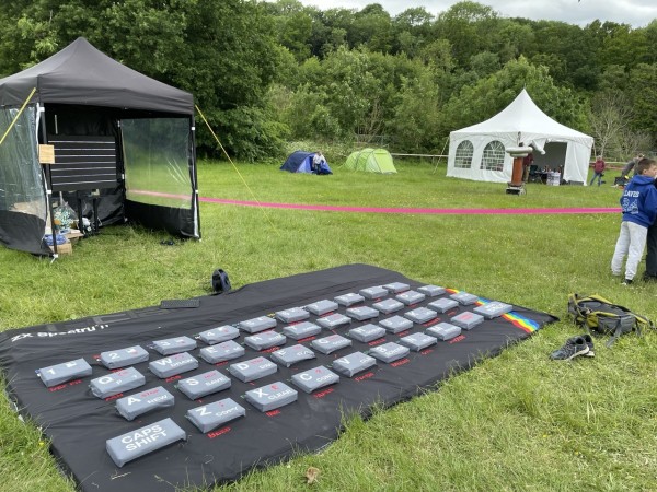 A giant ZX Spectrum in a field, with an also giant tesla coil in the background 