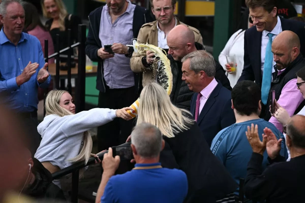 Woman throwing a banana milkshake right in Farage's face