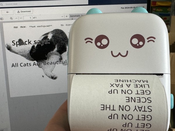 On the right is a cheap Bluetooth “cat printer”, with a printout of a received fax. On the left is the Cat Facts fax that has been sent in reply, featuring a picture of a black and white cat and a cat fact. 