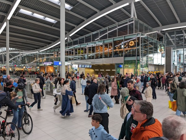 Group of people waiting outside of the fare gates at Utrecht Centraal station 