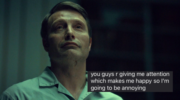 Still image. Mads Mikkelsen as Hannibal Lecter, shown alone in the frame, from the chest up, wearing a rough institutional twill shirt, top button unbuttoned. Neutral face to slightly mirthful smile. 

Bottom text reads:
you guys r giving me attention
which makes me happy so i'm
going to be annoying
