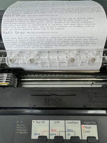 Dot matrix printer with a sheet of a4 in it. 
Multiple iterations of formatting a lorem ipsum toot, showing Matt Gray in large text, @mattgrayyes@chaos.social in normal text, a dividing line, then lorem ipsum justified to fit the width but with line breaks between the words. 