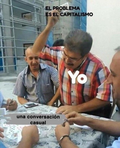Still image. Multiple people sitting around a table playing cards, one person is about to throw down an incredible hand, cards raised above their head. 

Cards are labeled:
EL PROBLEMA
ES EL CAPITALISMO

Person is labeled:
Yo

Table full of cards is labeled:
una conversación
casual