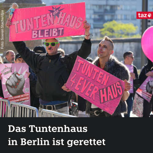 Das Bild zeigt zwei Bewohner*innen des Tunenhauses. Sie halten Schilder mit der Aufschrift „Tuntenhaus bleibt“ hoch. Darunter die Aufschrift: „Das Tuntenhaus in Berlin ist gerettet.“