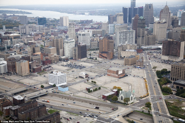 Photo of downtown Detroit showing highways and surface parking lots with buildings in the background