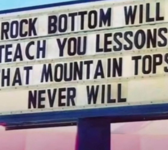 Sign displaying the message: "Rock bottom will teach you lessons that mountain tops never will."