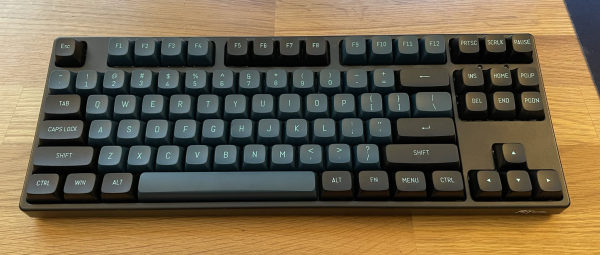 Tenkeyless wireless keyboard, with a two-tone color scheme (black and dark teal)
