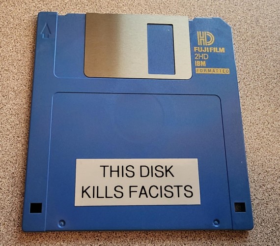 a blue 3.5" floppy disk, with a label reading THIS DISK KILL FACISTS 