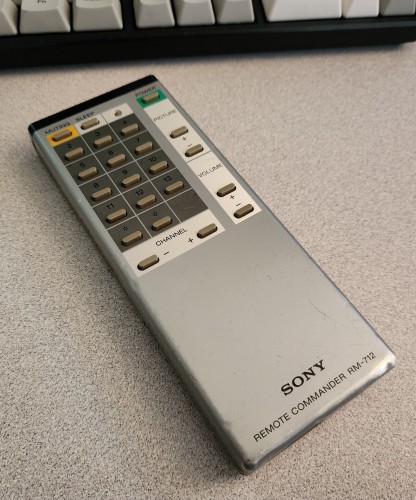 A grey metallic Sony remote. It has horizontal grey buttons, with rounded edges. 