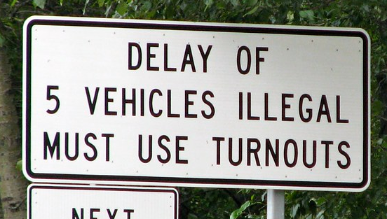 Road sign - "DELAY OF 5 VEHICLES ILLEGAL MUST USE TURNOUTS"