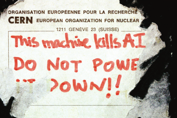 A picture of a sticker on a black surface, part ripped off, that reads "This machine kills AI DO NOT POWER IT DOWN!!". It's a modified version of the sticker on Tim Berners Lee's NeXT cube that originally read "This machine is a server".