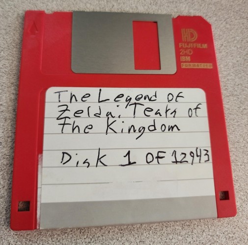 A 3.5" floppy disk with a hand written label, reading "The Legend of Zelda: Tears of the Kingdom, Disk 1 of 12943" 