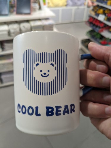 A coffee mug that says "Cool bear" with a smiling bear face.